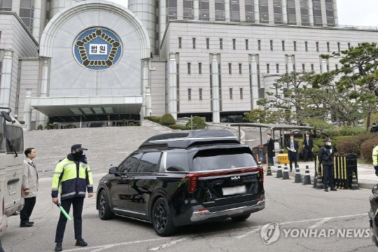 내란 우두머리 혐의로 기소된 윤석열 전 대통령의 첫 형사재판이 열리는 14일 윤 전 대통령이 탑승한 차량이 서울 서초구 서울중앙지방법원 지하주차장으로 들어가고 있다. 연합뉴스